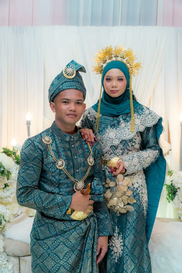 Pasangan pengantin dengan busana adat berwarna hijau toska