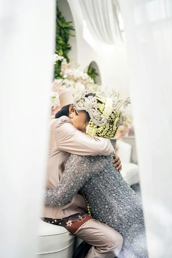 Pasangan pengantin Sunda saling berpelukan